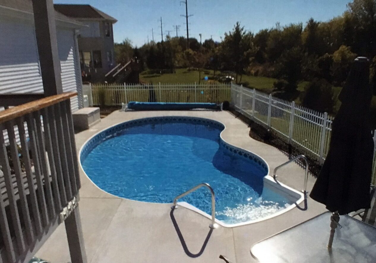 KIDNEY A pool with a fence and stairs in the middle of it