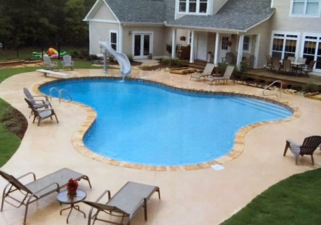 A pool with chairs and tables in the middle of it