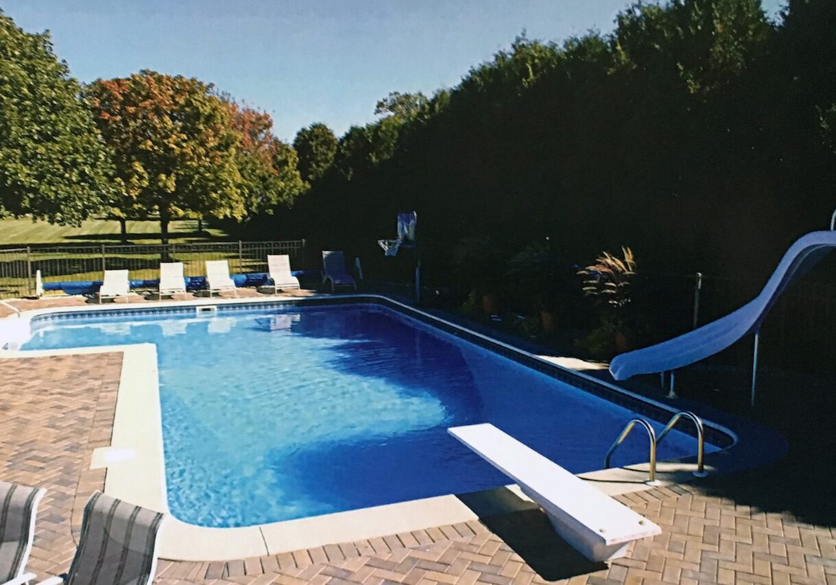 TRUE L A swimming pool with a bench and chairs in it